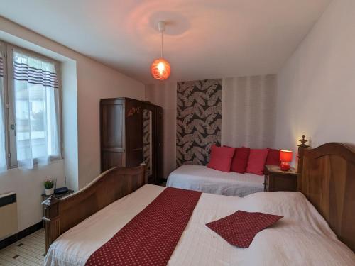 een slaapkamer met 2 bedden en rode kussens bij Gîte Jeu-Maloches, 4 pièces, 7 personnes - FR-1-591-60 in Jeu-Maloches