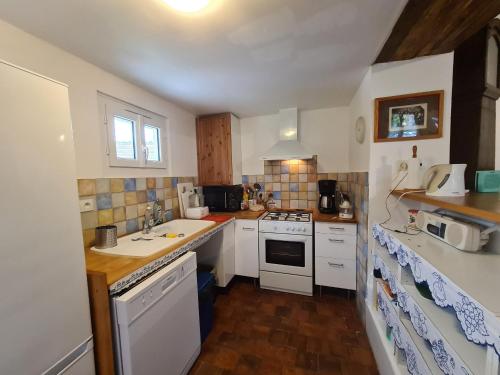 une petite cuisine avec des armoires blanches et un évier dans l'établissement Charmante maison dans le Parc de la Brenne, idéale pour familles avec jardin, proche zoo et activités nature - FR-1-591-83, à Pouligny-Saint-Pierre