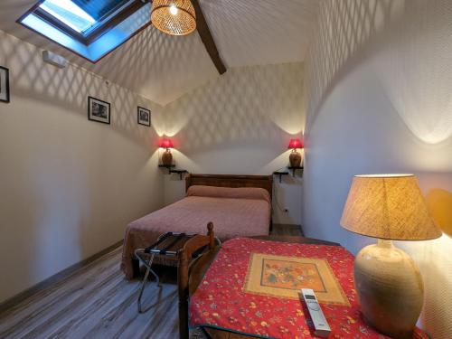 a bedroom with two beds and a table with a lamp at Gîte familial près de Nohant avec jardin, cheminée, garage et WIFI gratuit - FR-1-591-94 in Nohant-Vic