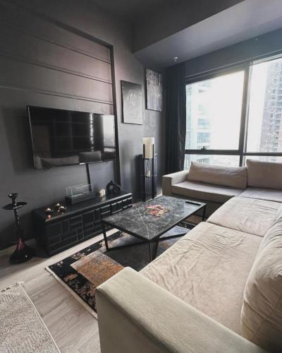 een woonkamer met een bank en een flatscreen-tv bij REZİDANS in Istanbul
