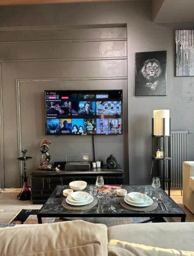 een woonkamer met een tafel en een televisie bij REZİDANS in Istanbul