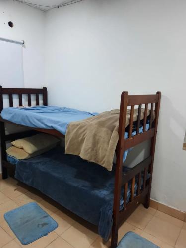 łóżko piętrowe w pokoju z niebieską pościelą i poduszkami w obiekcie Lo de Milo w mieście Presidencia Roque Sáenz Peña