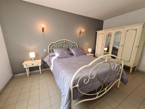 1 Schlafzimmer mit einem Bett, 2 Tischen und einem Spiegel in der Unterkunft Gîte Villentrois-Faverolles-en-Berry, 6 pièces, 10 personnes - FR-1-591-47 in Villentrois