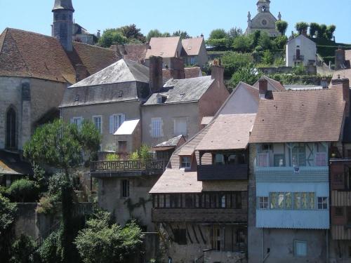 un groupe de maisons dans une ville avec une tour dans l'établissement Gîte familial calme avec jardin, près du lac d'Éguzon et des plus beaux villages de la Creuse - FR-1-591-100, à Saint-Plantaire