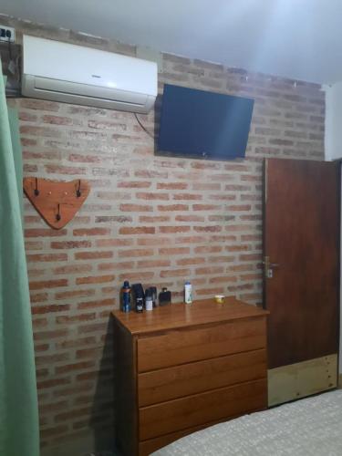 Pokój ze ścianą z telewizorem i komodą w obiekcie Lo de Milo w mieście Presidencia Roque Sáenz Peña