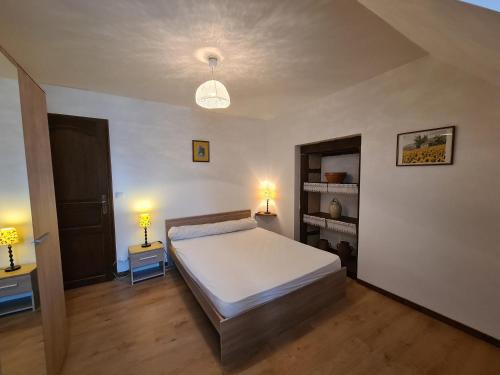 a bedroom with a bed and two night stands and two lamps at Maison paisible avec jardin clos, terrasse, proche lac d'Eguzon et villages médiévaux - FR-1-591-102 in Vigoux