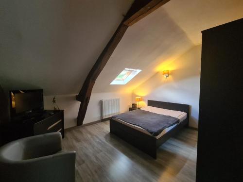 um quarto com uma cama e uma televisão num sótão em Gîte Le Pont-Chrétien-Chabenet, 3 pièces, 4 personnes - FR-1-591-57 