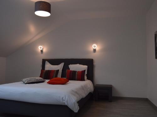 Schlafzimmer mit einem Bett mit weißer Bettwäsche und roten Kissen in der Unterkunft Gîte Brion, 5 pièces, 15 personnes - FR-1-591-188 in Brion