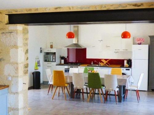 - une cuisine avec une table à manger et des chaises dans l'établissement Gîte rénové avec jardin clos, proche plages, Wifi, parking pour voiture électrique - FR-1-426-164, à Le Bernard
