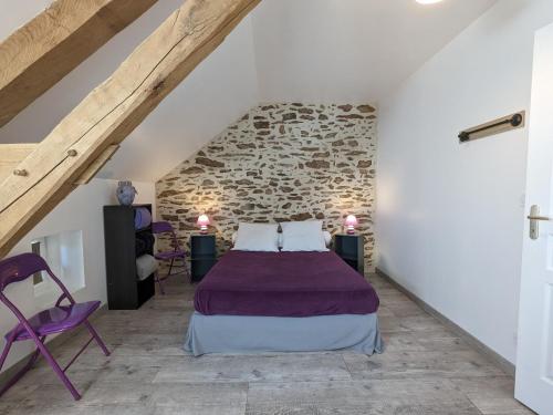 ein Schlafzimmer mit einem Bett und einer Steinmauer in der Unterkunft Gîte Pouligny-Notre-Dame, 3 pièces, 6 personnes - FR-1-591-134 in Pouligny-Notre-Dame