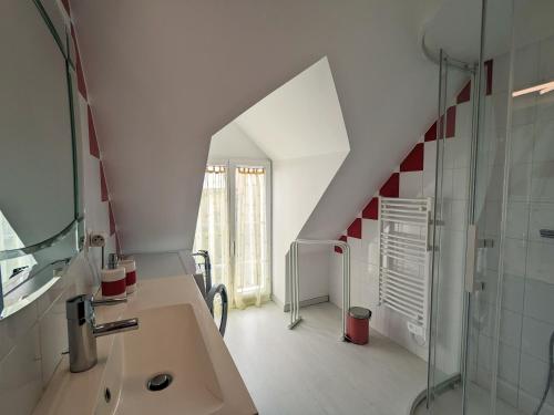 une salle de bain avec un lavabo et une douche en verre dans l'établissement Gîte chaleureux à 20min du Zoo de Beauval avec terrasse, climatisation et jeux extérieurs - FR-1-591-198, à Villentrois