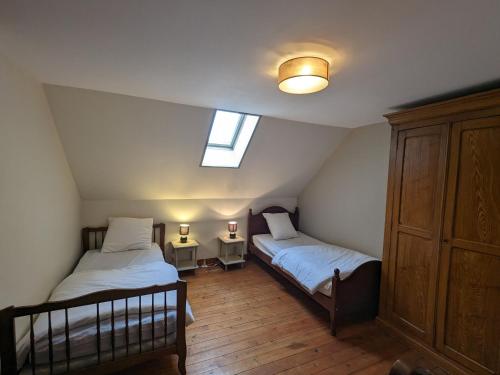 a attic bedroom with two beds and a window at Charmant Gîte Familial avec Grand Terrain, à Proximité de Fontgombault et de la Creuse - FR-1-591-118 in Sauzelles