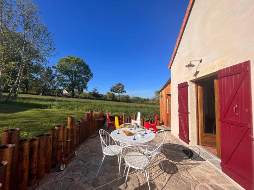 a patio with a table and chairs in a yard at Gîte "Tout Inclus" en Campagne Berrichonne avec Terrasse & Parking Privé - FR-1-591-419 in Briantes