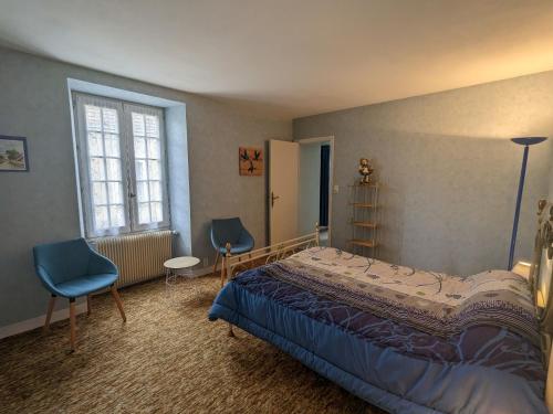 una camera da letto con un letto, due sedie e una finestra di Maison spacieuse avec cour et cheminée au cœur du Parc Naturel de la Brenne - FR-1-591-229 a Mézières-en-Brenne