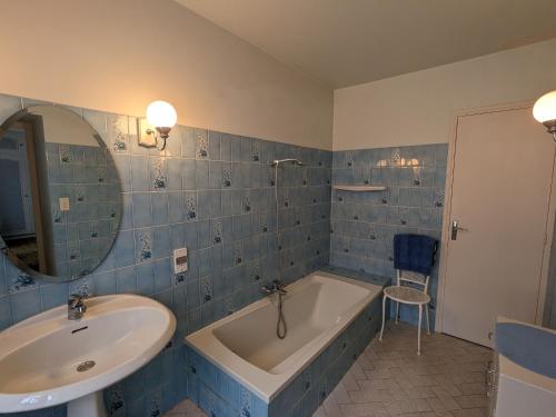 baño de azulejos azules con bañera y lavamanos en Gîte Mézières-en-Brenne, 3 pièces, 5 personnes - FR-1-591-229, en Mézières-en-Brenne