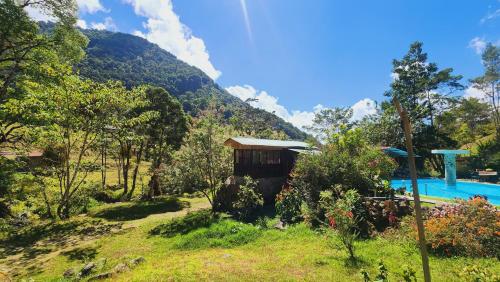 a resort with a swimming pool and a mountain at Hospedajes Richie Eco Camp in Providencia