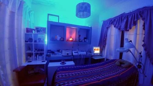 um quarto com uma cama num quarto com luzes azuis em Habitación privada, La Plata em La Plata