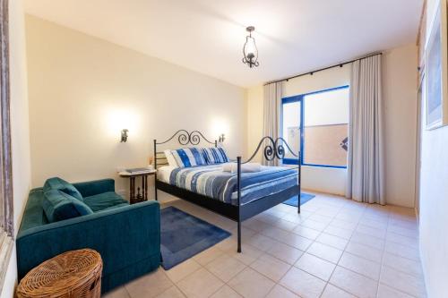 ein Schlafzimmer mit einem Bett und einem Sofa in der Unterkunft Casita Alegra Beachfront family friendly in Port Elliot