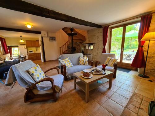 un salon avec un canapé et une table dans l'établissement Ancien moulin avec piscine, terrasse, jardin privatif et petite île - près des étangs de la Brenne - FR-1-591-159, à Prissac