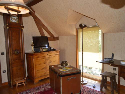- un salon avec une télévision sur une commode et une horloge dans l'établissement Maison de campagne rénovée avec jardin, à proximité de Valençay et du Zoo de Beauval - FR-1-591-287, à Veuil