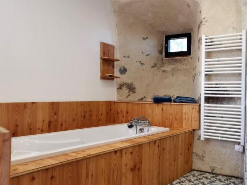 a bath tub in a bathroom with wooden walls at Maison de vacances rénovée, entre nature et ville, proche du Puy-en-Velay - FR-1-582-321 in Arsac-en-Velay