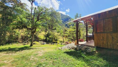 a house with a deck next to a field at Hospedajes Richie Eco Camp in Providencia