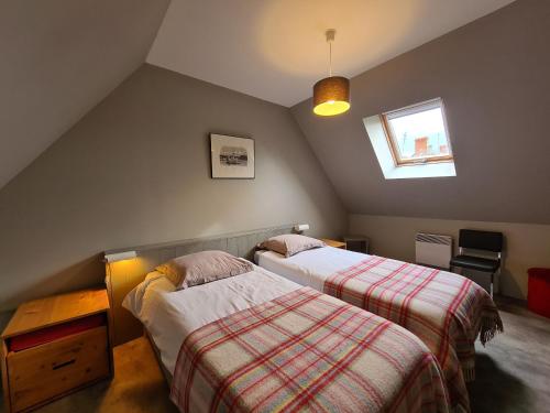 a attic bedroom with two beds and a window at Gîte de charme en Berry avec jardin privatif, idéal pour randonnées et observation des oiseaux - FR-1-591-184 in Rosnay