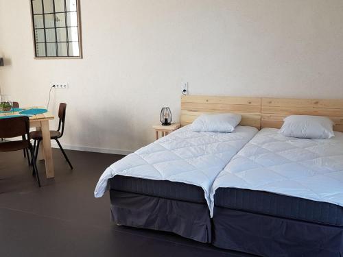 1 dormitorio con 1 cama y 1 mesa con silla en Gîte Lingé, 2 pièces, 2 personnes - FR-1-591-189, en Lingé