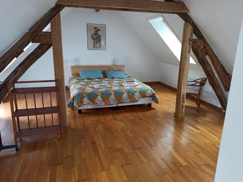 a bedroom with a bed and a wooden floor at Charmante Longère avec Terrasse et Piscine Chauffée, proche châteaux et zoo, en pleine nature - FR-1-591-240 in Saint-Lactencin