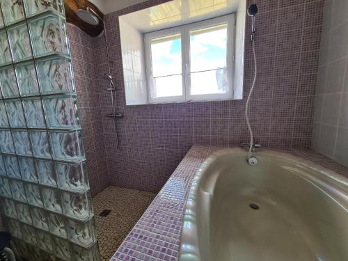ein Bad mit einer Badewanne und einem Fenster in der Unterkunft Gîte Saint-Lactencin, 4 pièces, 8 personnes - FR-1-591-240 