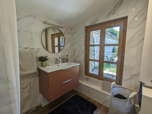 baño con lavabo, espejo y ventana en Gîte Châteauroux, 2 pièces, 4 personnes - FR-1-591-550, en Châteauroux