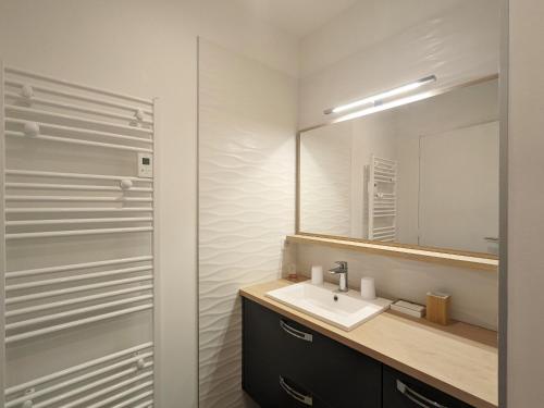 une salle de bain avec un lavabo et un miroir dans l'établissement Appartement de Charme au Parc Balsan - Châteauroux, Près Centre Aquatique et Loisir - FR-1-591-556, à Châteauroux