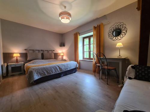 ein Schlafzimmer mit einem Bett, einem Tisch und einem Stuhl in der Unterkunft Gîte Vigoulant, 5 pièces, 11 personnes - FR-1-591-333 in Vigoulant