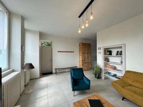 un salon avec un canapé et une table dans l'établissement École rénovée avec terrasse, 3 chambres, draps, ménage et chauffage inclus - FR-1-591-344, à Paudy