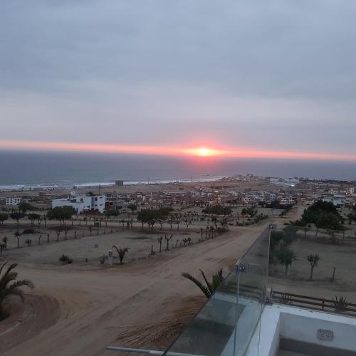 a sunset over a city with a dirt road at CASA DE PLAYA Durante todo el año in Punta Negra
