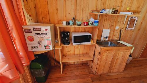 a small kitchen with a microwave and a sink at Hospedajes Richie Eco Camp in Providencia