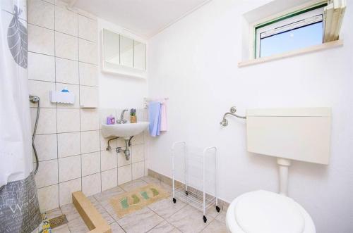 uma casa de banho com um WC e um lavatório em Secluded holiday house Postira, Brac - 22199 em Postira