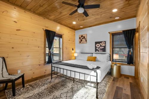 a bedroom with a bed and a ceiling fan at SmokiesBoutiqueCabins would love to host you at our NEW cabin! 3 King Suites, Indoor Pool, Game Room, Lounge with 75" TV! Close to Dollywood and the Parkway! in Pigeon Forge