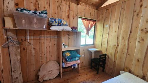 a room with a wooden cabin with a bed and a window at Hospedajes Richie Eco Camp in Providencia