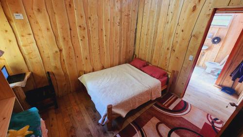 a small bedroom with a bed in a wooden cabin at Hospedajes Richie Eco Camp in Providencia