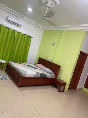 ein Schlafzimmer mit einem Bett in einem Zimmer mit grünen Wänden in der Unterkunft Timba chic-villa in Abomey-Calavi