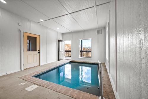 a swimming pool in the middle of a house at SmokiesBoutiqueCabins would love to host you at our NEW cabin! 3 King Suites, Indoor Pool, Game Room, Lounge with 75" TV! Close to Dollywood and the Parkway! in Pigeon Forge