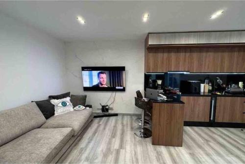 uma sala de estar com um sofá e uma televisão de ecrã plano em Luxury penthouse em Santa Cruz de Tenerife