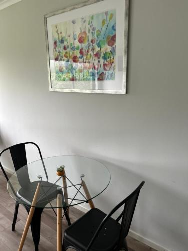 a glass table and a chair and a picture on the wall at La casona Talpen in Constitución