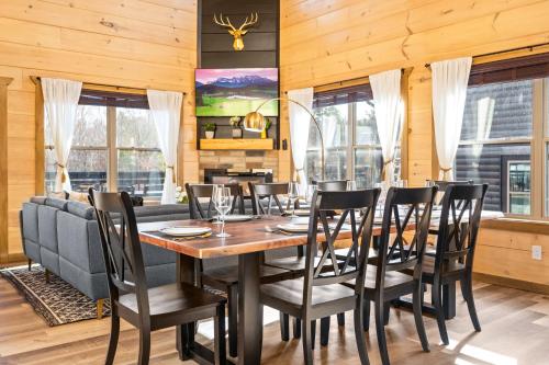 a dining room with a table and chairs at SmokiesBoutiqueCabins would love to host you at our NEW cabin! 3 King Suites, Indoor Pool, Game Room, Lounge with 75" TV! Close to Dollywood and the Parkway! in Pigeon Forge