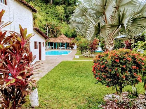 un patio del complejo con piscina y palmeras en Hermosa Finca en Doradal en Doradal