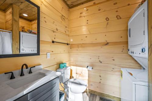 a bathroom with wooden walls and a toilet and a sink at SmokiesBoutiqueCabins would love to host you at our NEW cabin! 3 King Suites, Indoor Pool, Game Room, Lounge with 75" TV! Close to Dollywood and the Parkway! in Pigeon Forge