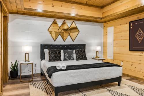 a bedroom with a large bed and two lamps at SmokiesBoutiqueCabins would love to host you at our NEW cabin! 3 King Suites, Indoor Pool, Game Room, Lounge with 75" TV! Close to Dollywood and the Parkway! in Pigeon Forge
