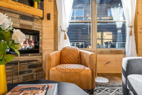 a living room with a chair and a fireplace at SmokiesBoutiqueCabins would love to host you at our NEW cabin! 3 King Suites, Indoor Pool, Game Room, Lounge with 75" TV! Close to Dollywood and the Parkway! in Pigeon Forge