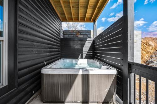 a jacuzzi tub in a black walled bathroom at SmokiesBoutiqueCabins would love to host you at our NEW cabin! 3 King Suites, Indoor Pool, Game Room, Lounge with 75" TV! Close to Dollywood and the Parkway! in Pigeon Forge